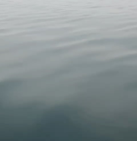 Monochromatic image of calm water surface with subtle ripples, creating a peaceful and serene visual effect in shades of gray and blue.