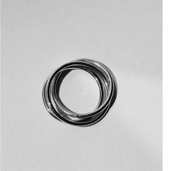 Overlapping silver rings interlock, creating a geometric pattern. The rings are centered, with light creating soft shadows on the white background.