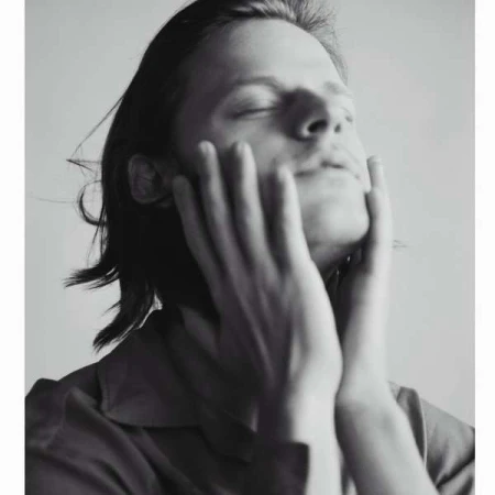 Portrait of a man holding his face with hands raised upward by Carlotta Manaigo