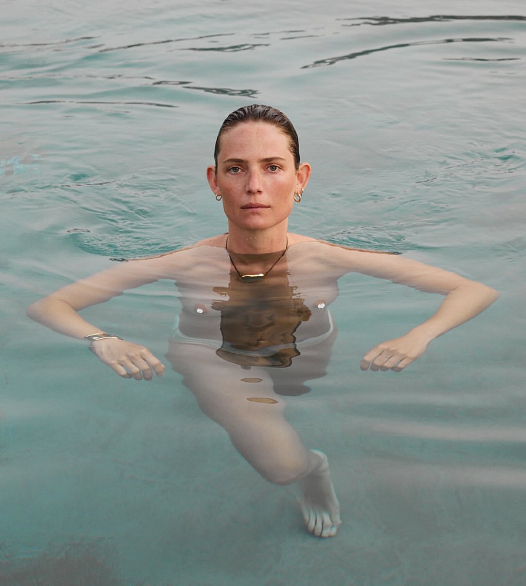 Portrait of a woman submerged in clear water up to her chest, photographed by Carlotta Manaigo.