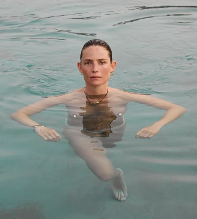 Portrait of a woman submerged in clear water up to her chest, photographed by Carlotta Manaigo.