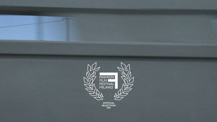 Fashion Film Festival Milano logo on a gray textured background with horizontal lines, an official selection emblem for 2020.