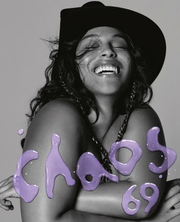 Close-up portrait of a laughing woman wearing a black hat with large purple lettering overlay reading CHAOS 69.