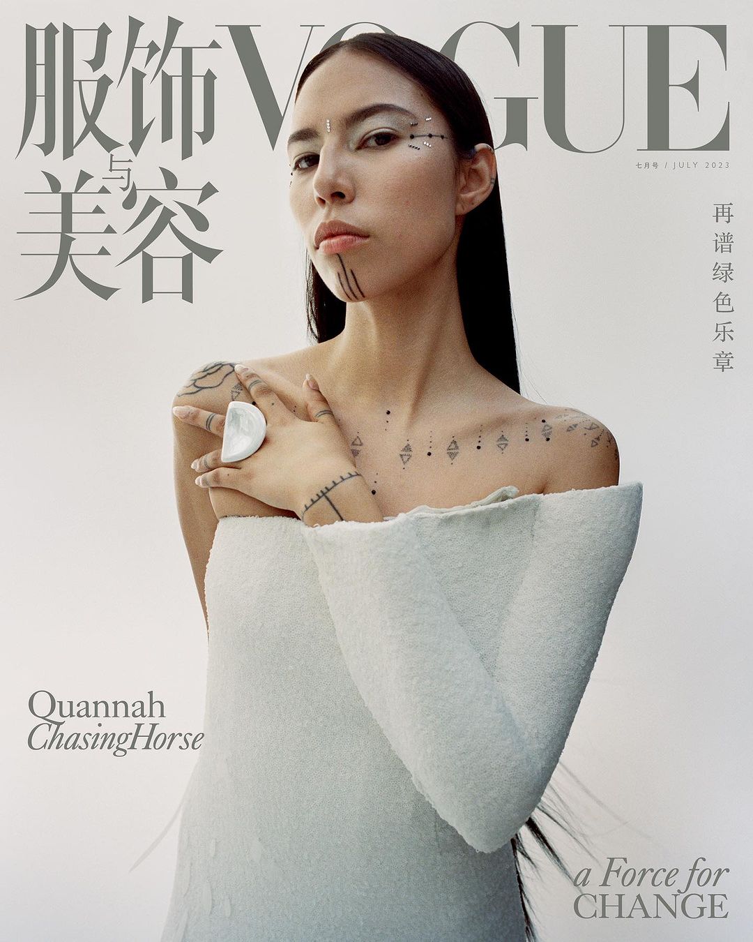 Vogue magazine cover featuring a young woman with decorative face and body markings, wearing a white textured dress against a white backdrop.
