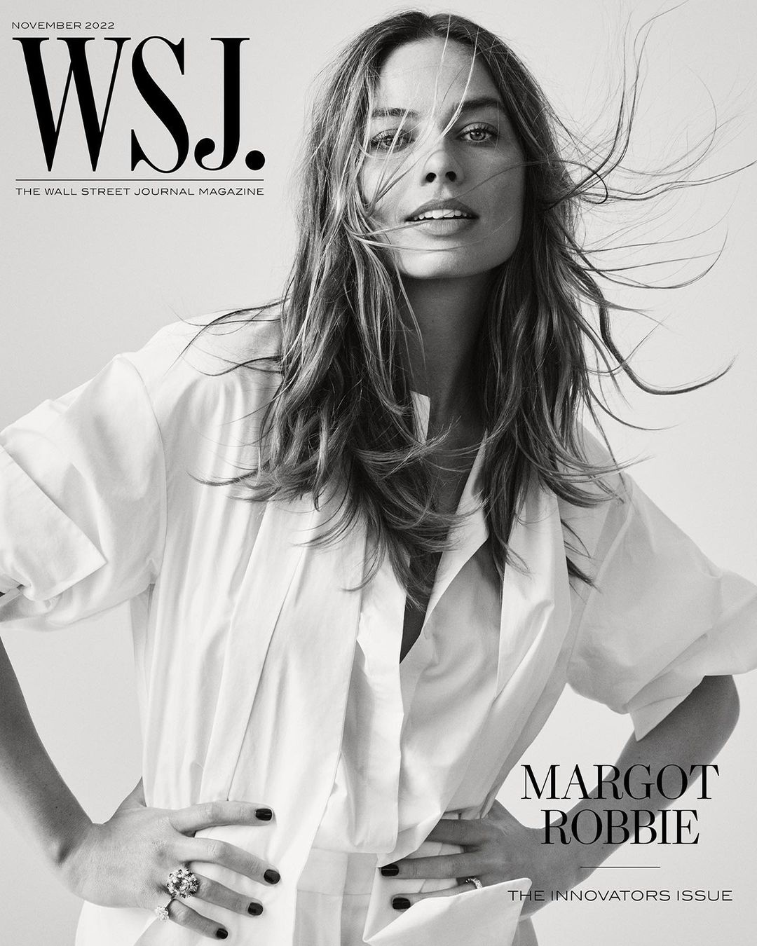 Margot Robbie on WSJ. Magazine cover, November 2022. Portrait of woman with long hair, wearing a white shirt, with hands on hips.