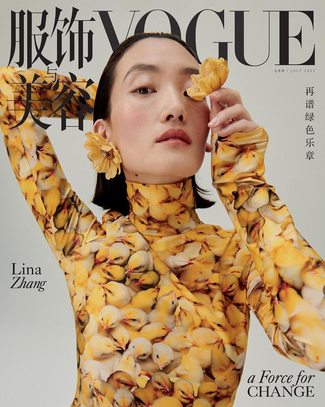 Vogue cover featuring a woman wearing a patterned yellow top and yellow flower earrings, holding a flower near her eye.