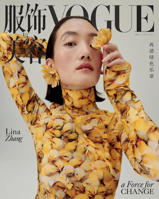 Vogue cover featuring a woman wearing a patterned yellow top and yellow flower earrings, holding a flower near her eye.