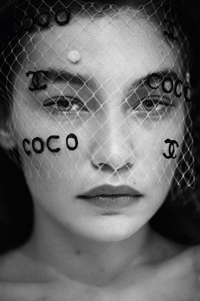 Black and white portrait of a woman with netting veil, featuring brand logos and text, showcasing beauty and fashion elements.