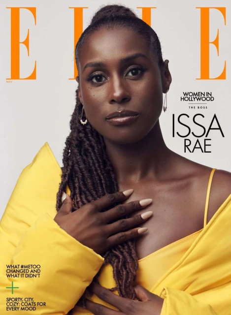 Issa Rae, a Black woman with long brown dreadlocks, is on the cover of Elle magazine wearing a yellow jacket and tan-colored nail polish.