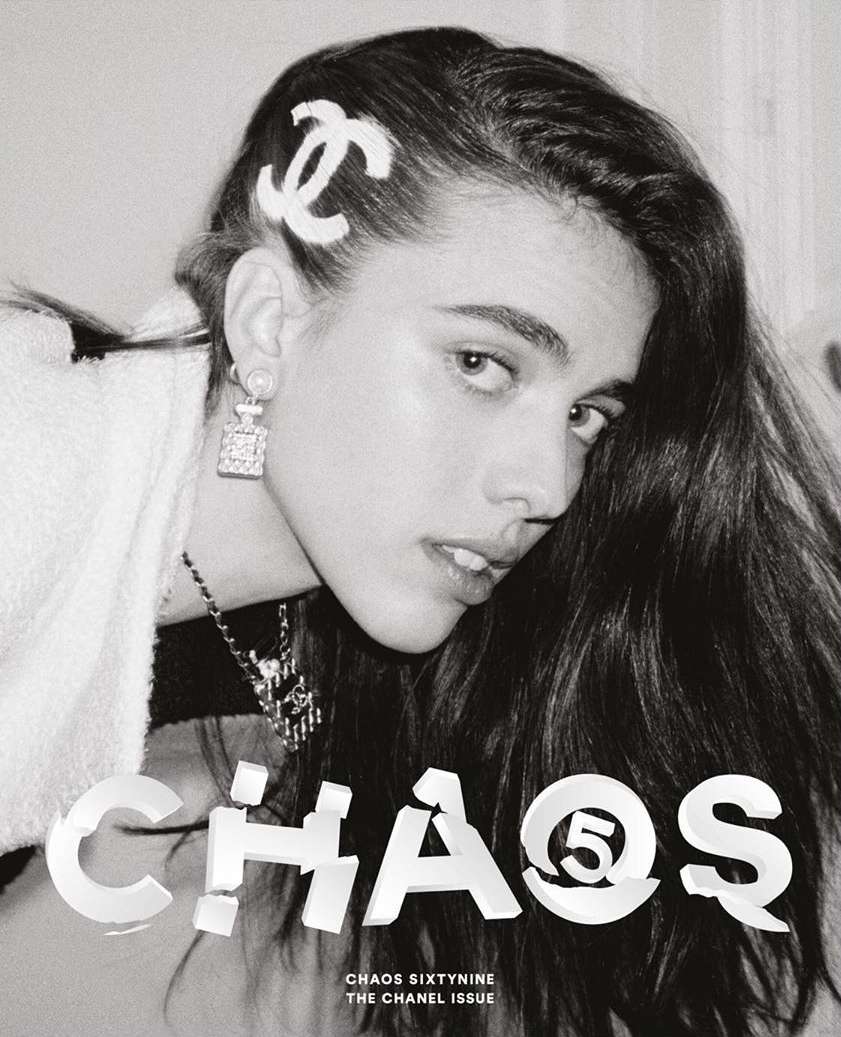 Black-and-white portrait of a woman with long hair wearing a Chanel hair clip and earrings, with 'CHAOS' text overlay.