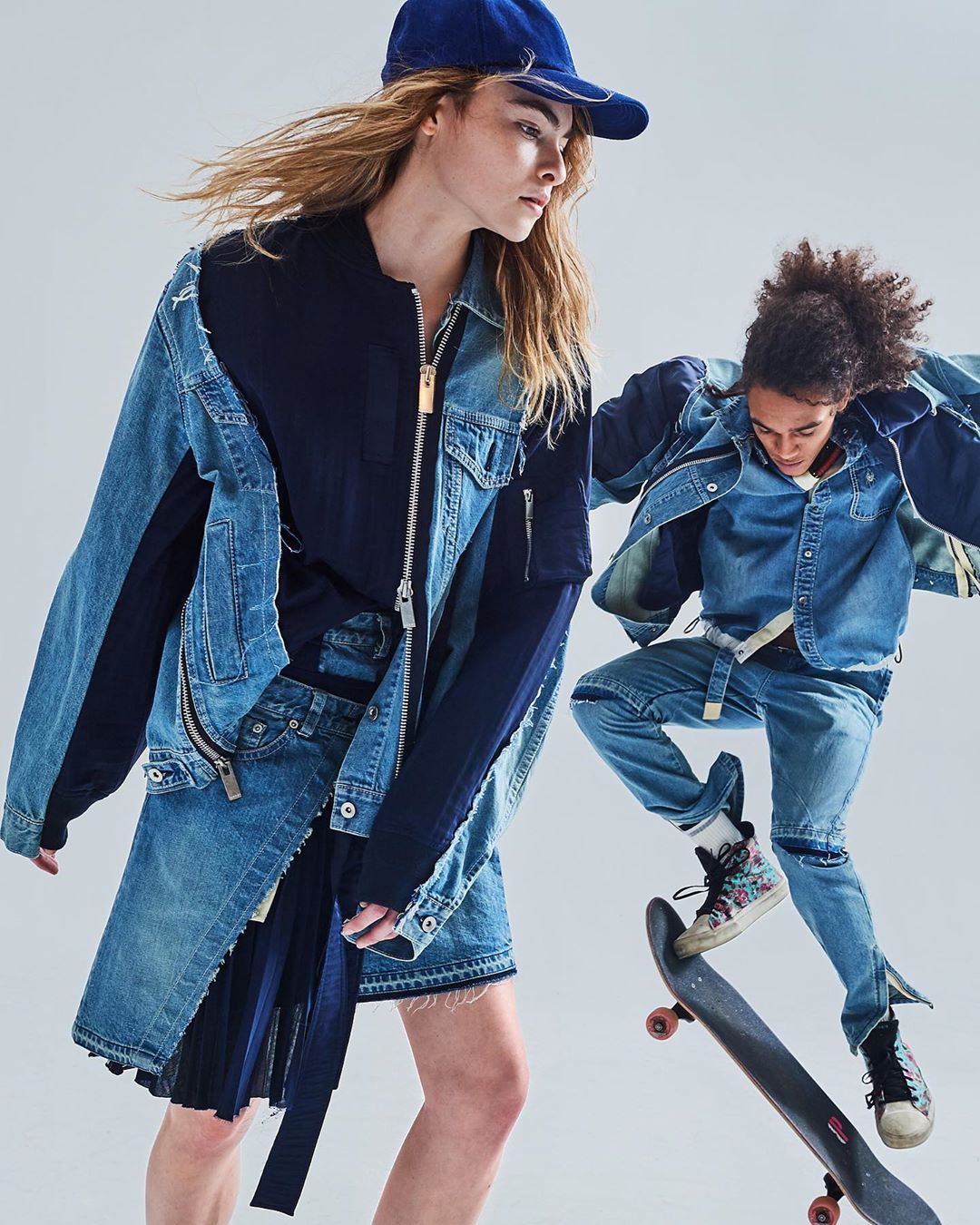 Two fashion models showcase denim outfits in a studio setting, one standing with a denim jacket and skirt, the other skateboarding mid-air.