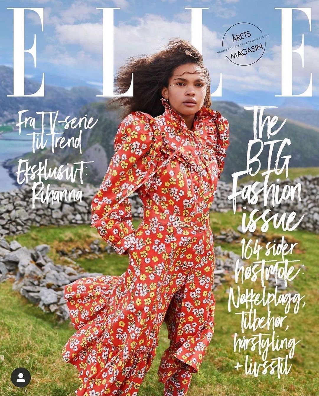 Elle magazine cover featuring a woman in a floral dress, set against a backdrop of mountains and a serene body of water.