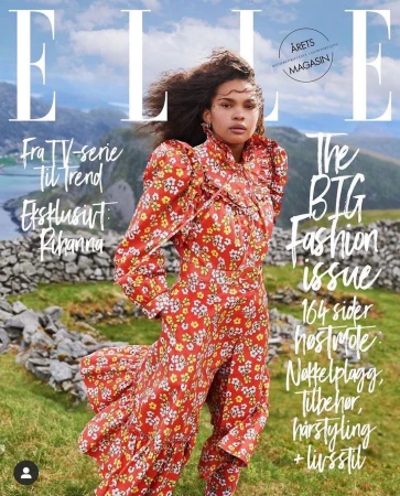 Elle magazine cover featuring a woman in a floral dress, set against a backdrop of mountains and a serene body of water.