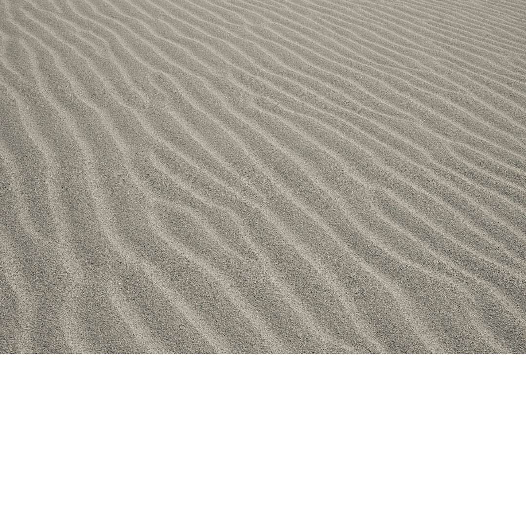 Wavelike patterns in the sand of a desert landscape, with soft light and natural textures, creating a serene and abstract image.