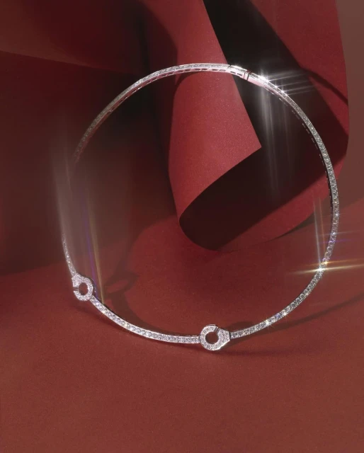 Elegant silver choker necklace with diamond embellishments on a red background with soft lighting for a sophisticated jewelry advertisement.