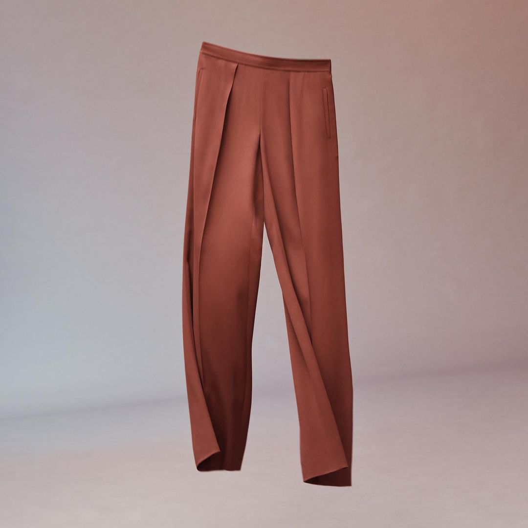 Pair of reddish-brown wide-leg trousers on a gradient background. Fashionable and stylish bottoms apparel for women.