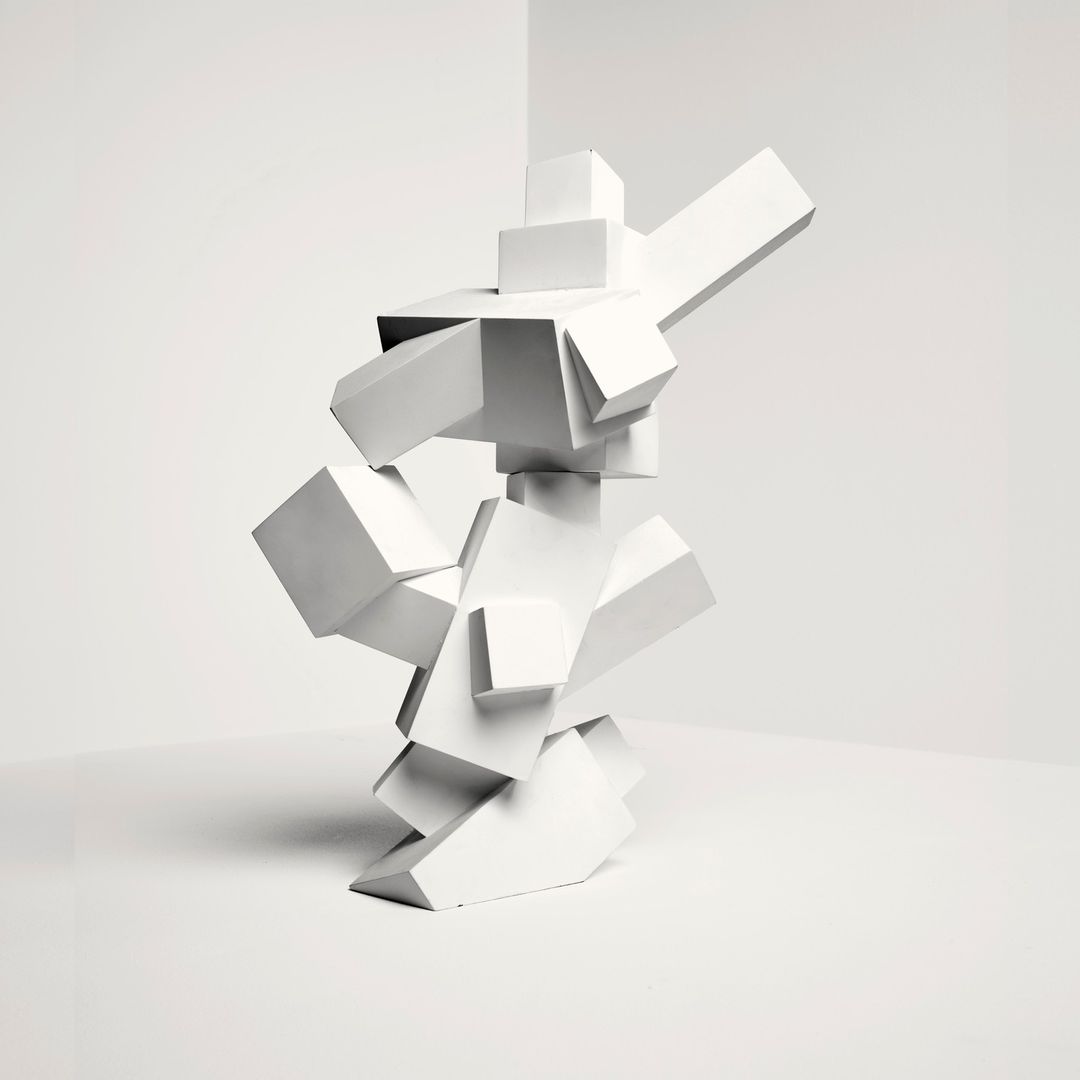 Abstract geometric sculpture of stacked white cubes in a bright, minimalist corner with bright, even lighting for a modern art display.