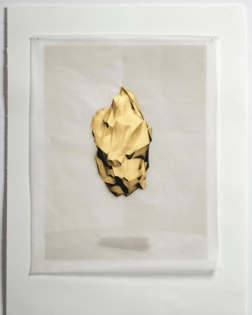 Geometric abstract art of a gold crumpled paper shape against a white background in a white frame under neutral studio lighting.