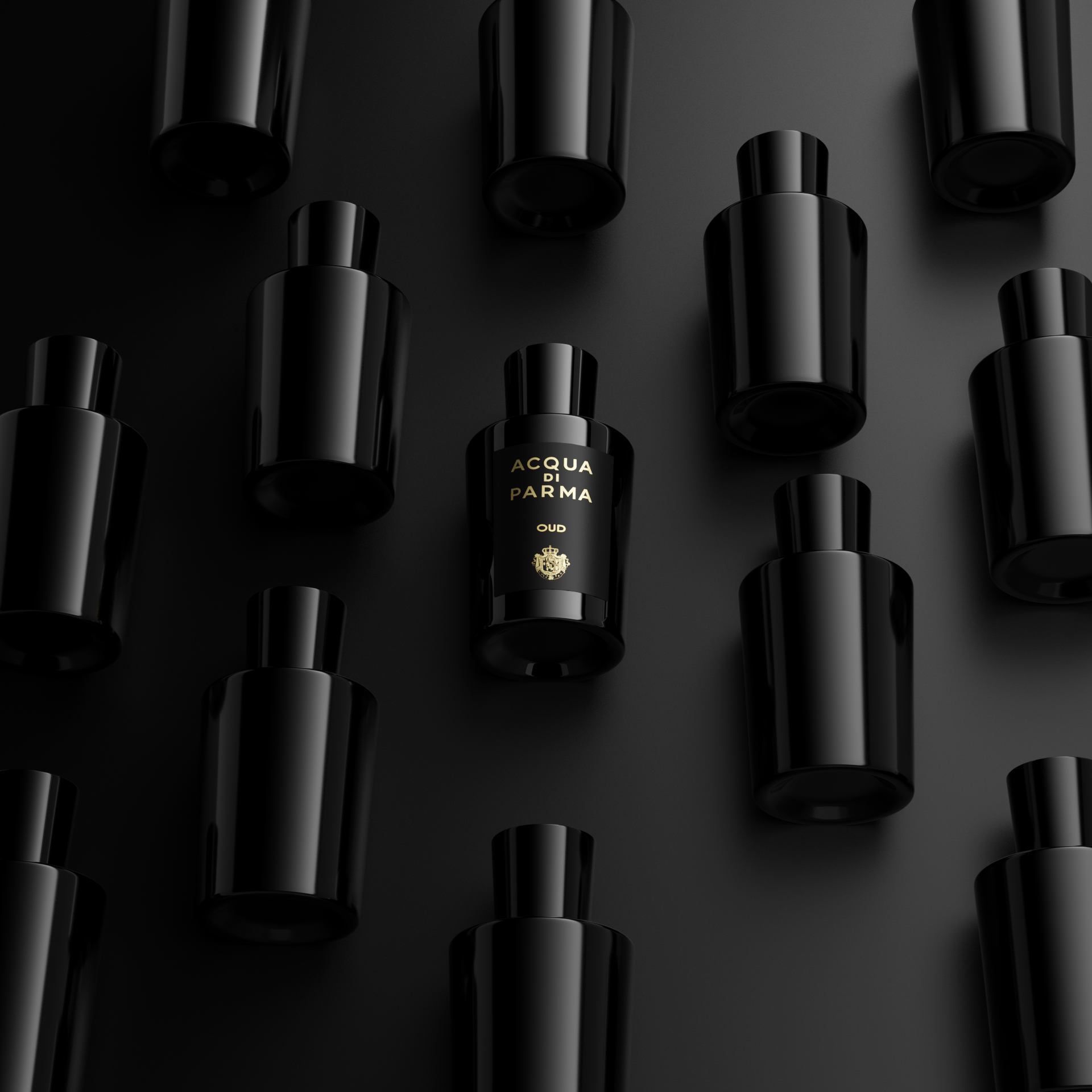 High-angle product shot featuring multiple black Acqua di Parma Oud perfume bottles arranged symmetrically on a dark black surface.