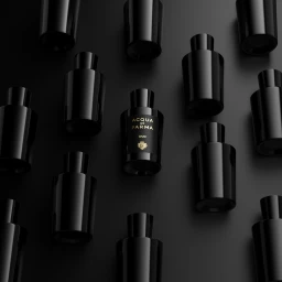 Array of glossy black Acqua di Parma Oud perfume bottles on a matte dark surface with one labeled bottle centered.
