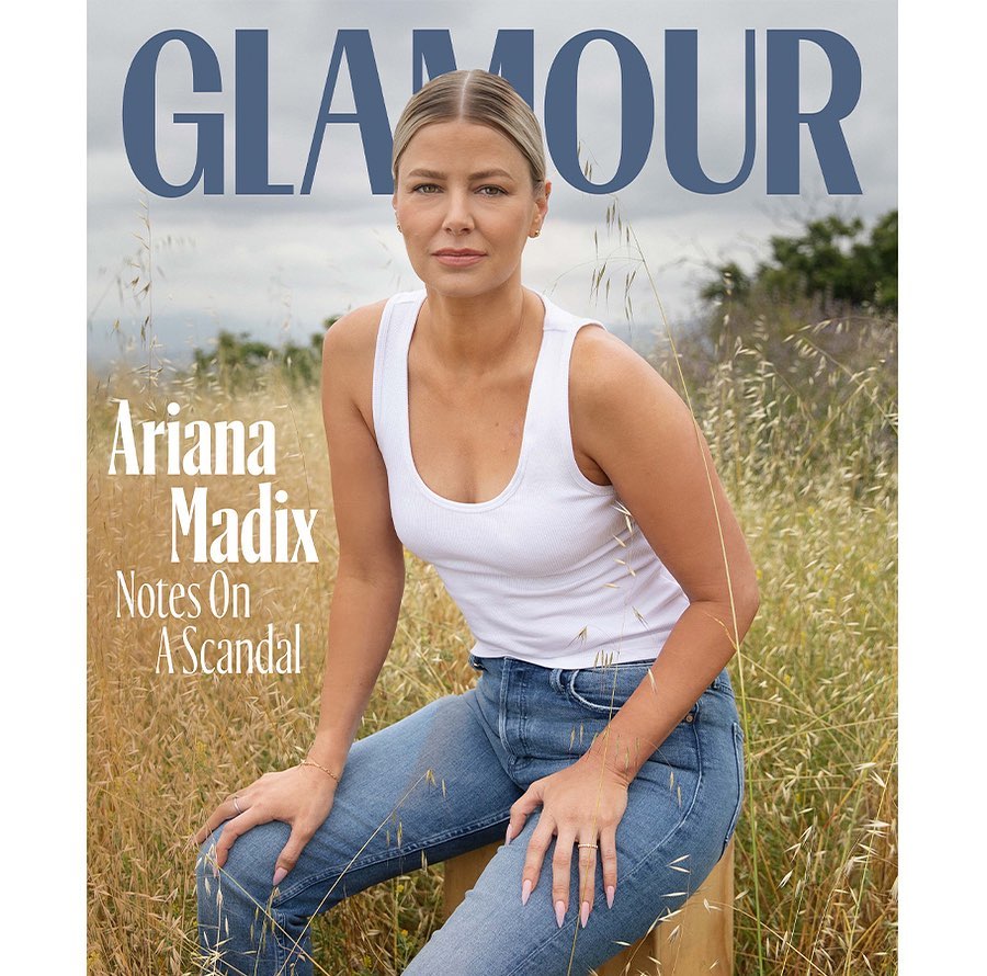 Glamour magazine cover featuring a woman sitting in a field, wearing a white tank top and blue jeans, with the magazine logo at the top.