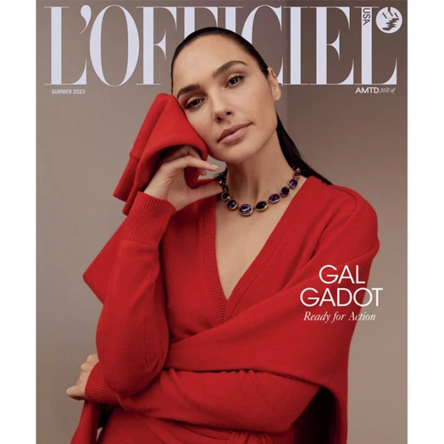 Gal Gadot on L'Officiel USA cover, Summer 2023. She wears a red V-neck sweater and a purple gemstone necklace in a neutral studio setting.