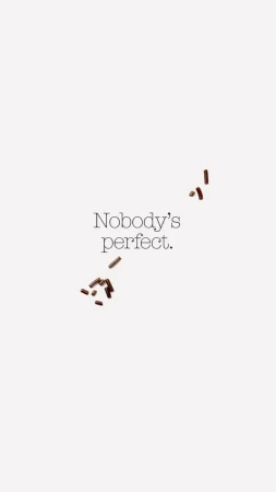 Scattered chocolate sprinkles on a white background with the text 'Nobody's perfect.' creates a minimalist, food-themed visual.
