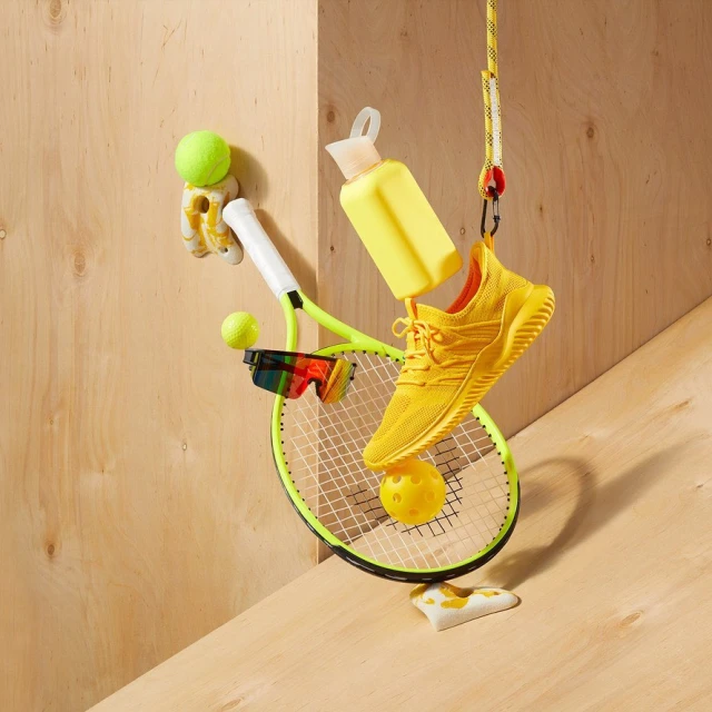 Still life of yellow athletic shoe, tennis racket, sport bottle, and tennis ball. Studio shot of sports and fitness accessories.