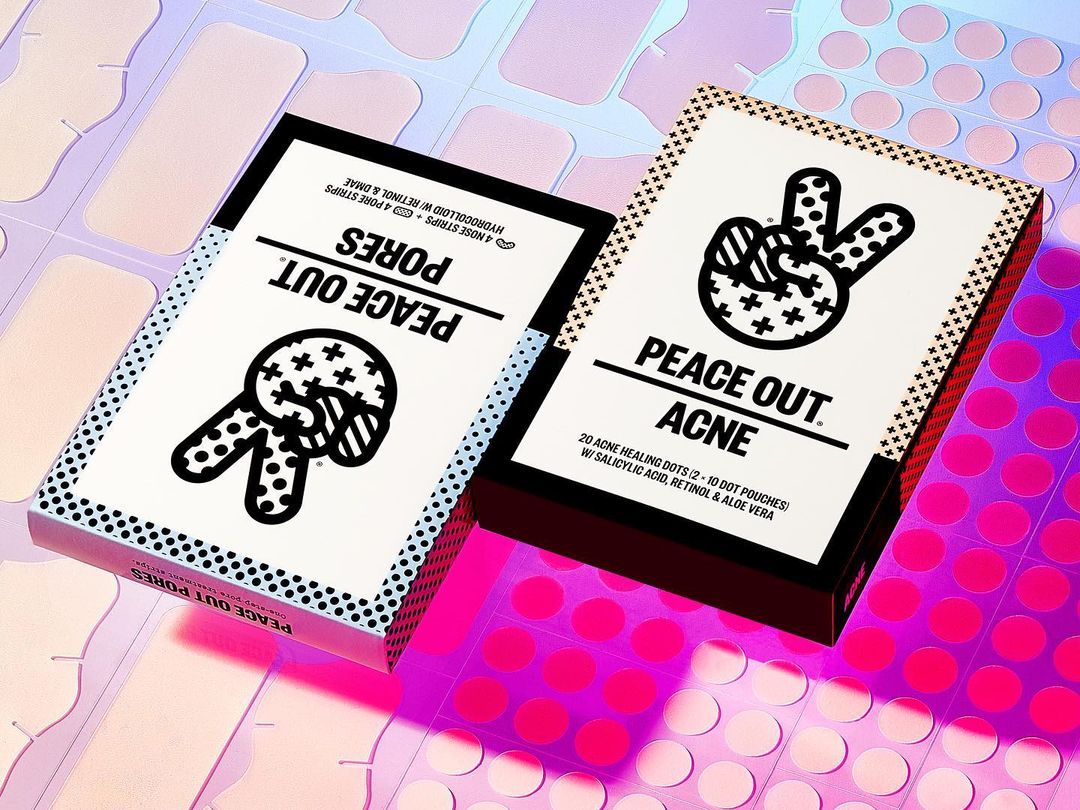 Two skincare boxes, Peace Out Acne and Peace Out Pores, are displayed on a pink and holographic surface with acne treatment patches.