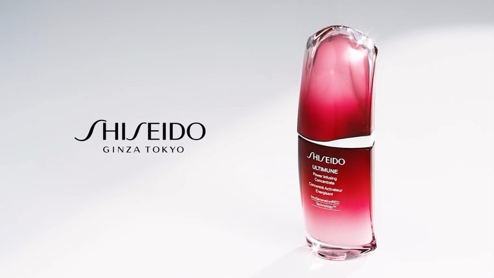 Elegant product shot of Shiseido Ultimune serum featuring a red and clear bottle against a bright white backdrop.