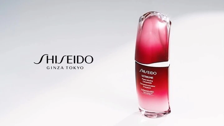 Elegant product shot of Shiseido Ultimune serum featuring a red and clear bottle against a bright white backdrop.