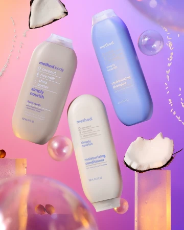 Three Method brand bottles of body wash, shampoo, and conditioner are displayed with coconuts and reflective spheres in a studio setting.