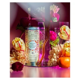 Bax Botanics beverage can surrounded by colorful flowers and a small citrus fruit by Cera Hensley