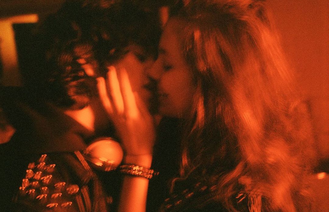 Close-up portrait of two young people in warm amber lighting, captured by Chad Moore in New York.