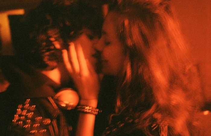 Close-up portrait of two young people in warm amber lighting, captured by Chad Moore in New York.
