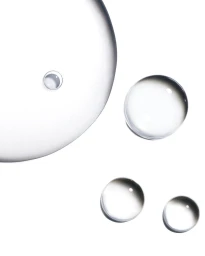 Macro view of transparent liquid droplets and bubbles scattered across a clean white surface