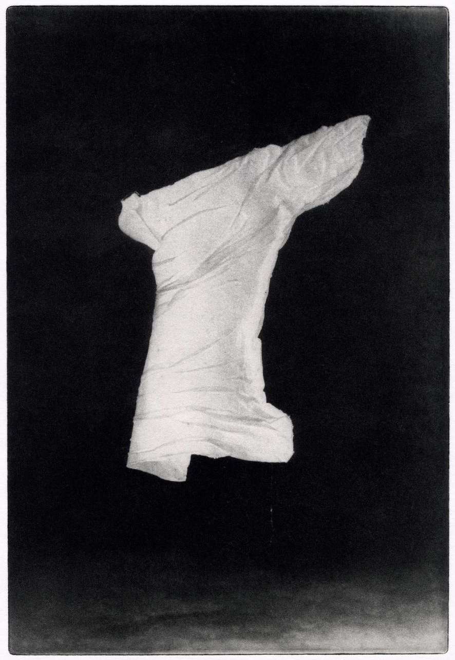 Abstract art featuring a single crumpled white cloth or piece of paper floating in a black void, creating a mysterious and stark contrast.