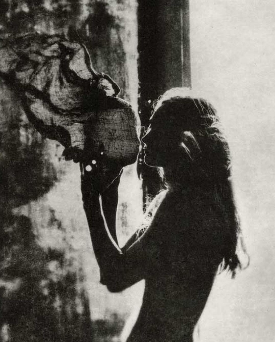 Monochrome profile portrait of a woman holding and examining a textured object in Paris by Chantal Elisabeth Ariens.