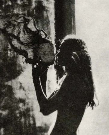 Monochrome profile portrait of a woman holding and examining a textured object in Paris by Chantal Elisabeth Ariens.