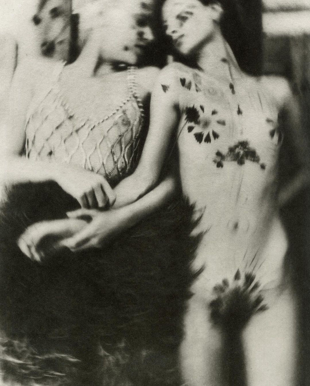 Two women posing together with floral and botanical decorations on skin in a photographic portrait by Chantal Elisabeth Ariens.