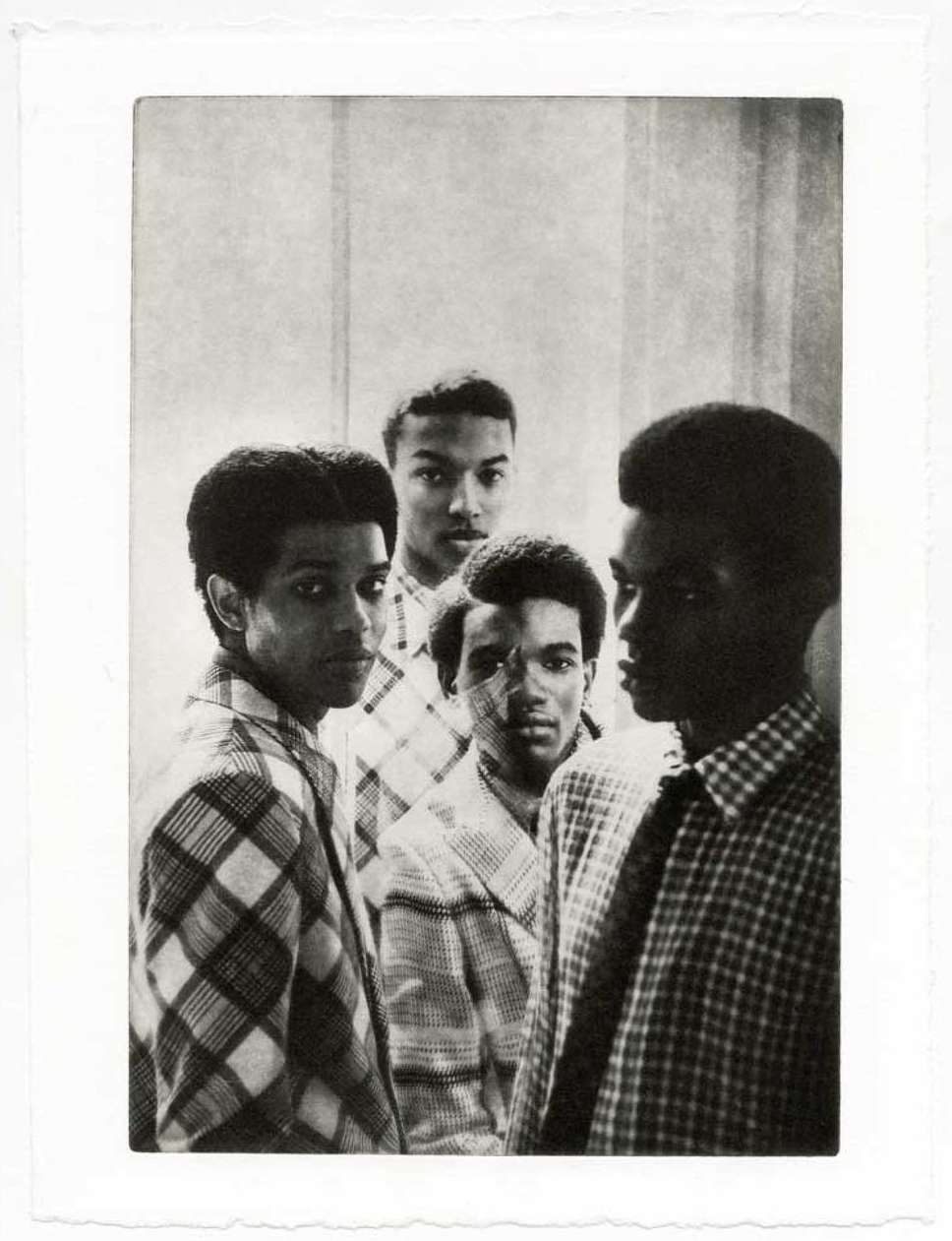 Black and white portrait of a group of young African American men wearing patterned shirts against a textured wall, fine art photography.