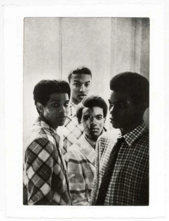 Black and white portrait of a group of young African American men wearing patterned shirts against a textured wall, fine art photography.