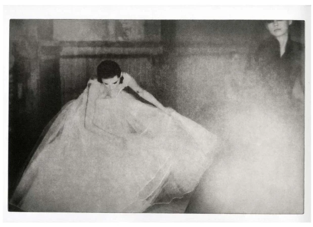 Model in a voluminous white gown posing in a moody interior captured by Chantal Elisabeth Ariens in Paris.