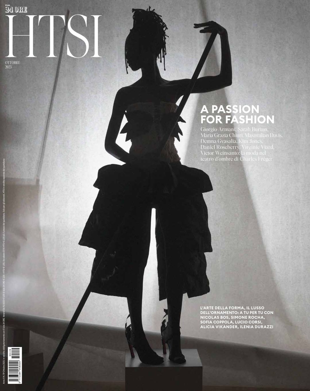 Fashion magazine cover featuring a silhouetted figure in avant-garde clothing, dramatic lighting, and bold typography.