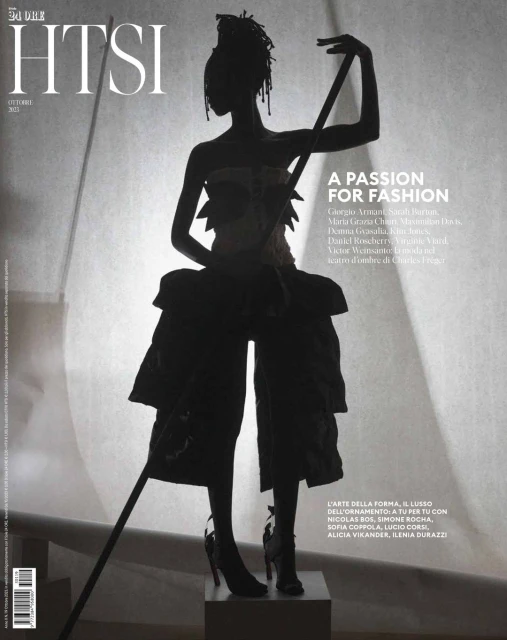 Fashion magazine cover featuring a silhouetted figure in avant-garde clothing, dramatic lighting, and bold typography.