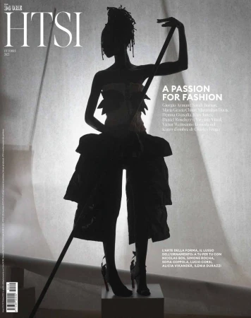 Fashion magazine cover featuring a silhouetted figure in avant-garde clothing, dramatic lighting, and bold typography.