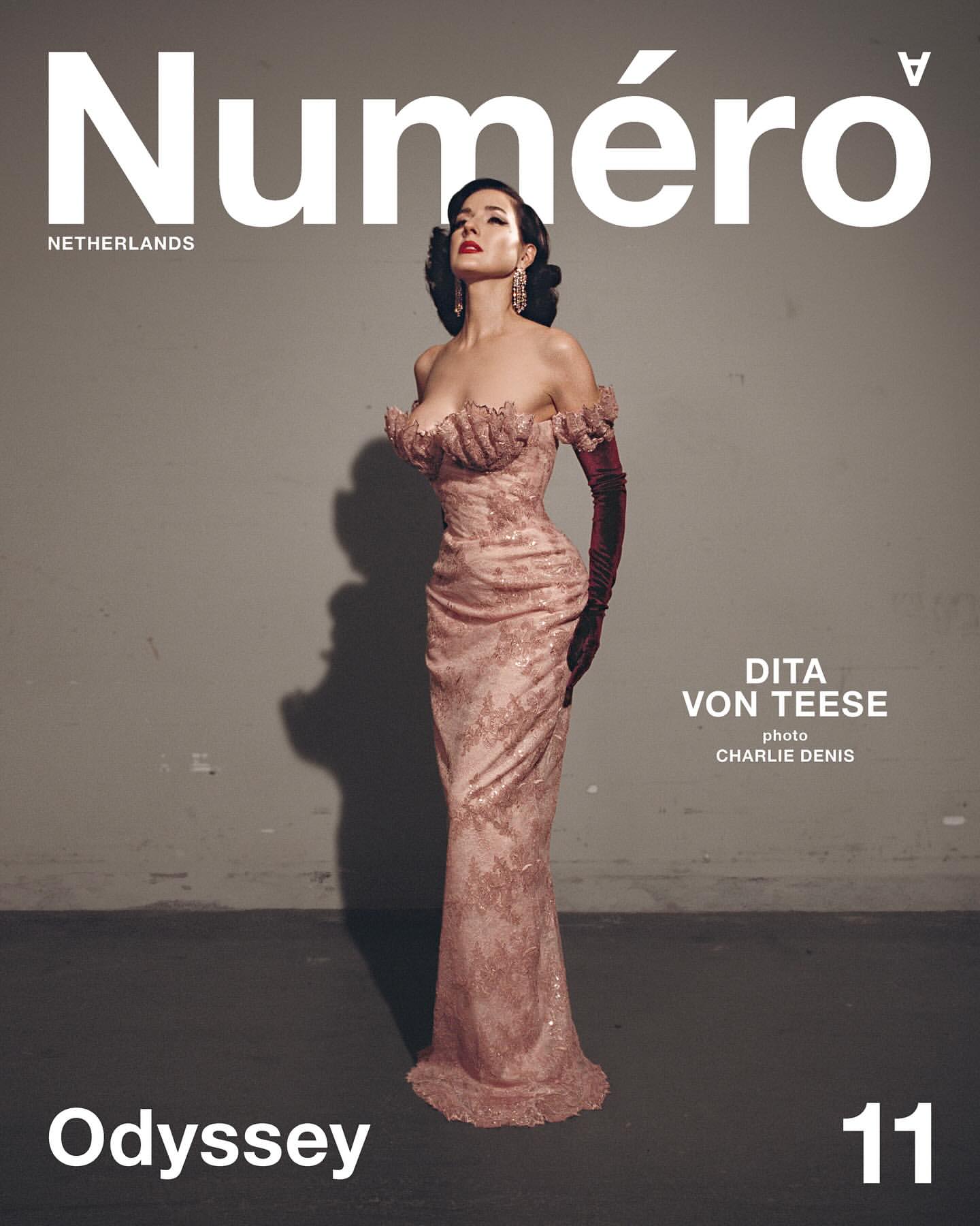 Dita Von Teese on the cover of Numéro Netherlands magazine in a pink gown with matching gloves against a grey backdrop.