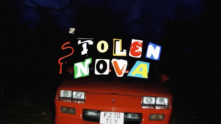 An overhead shot of a red coupe with the phrase 'Stolen Nova' floating above the hood in front of a dark night sky background.