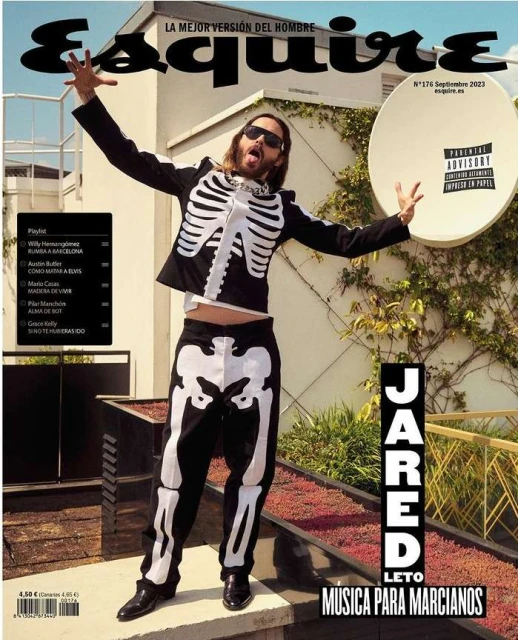 Esquire magazine cover featuring Jared Leto in skeleton-themed outfit, arms raised, set against an outdoor urban backdrop with greenery.