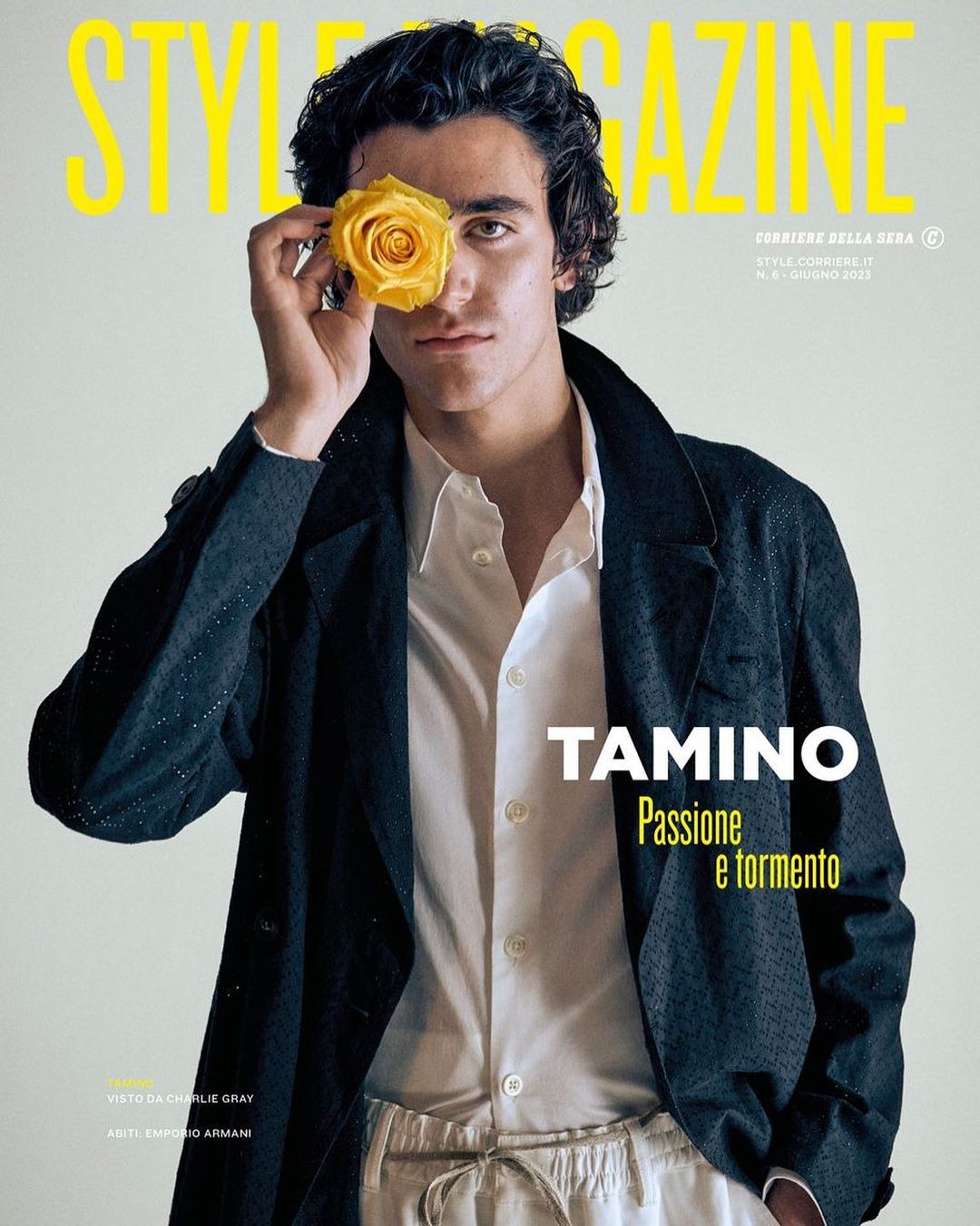 Magazine cover features a dark-haired male model with a yellow rose over his eye, wearing a dark jacket and light-colored pants.